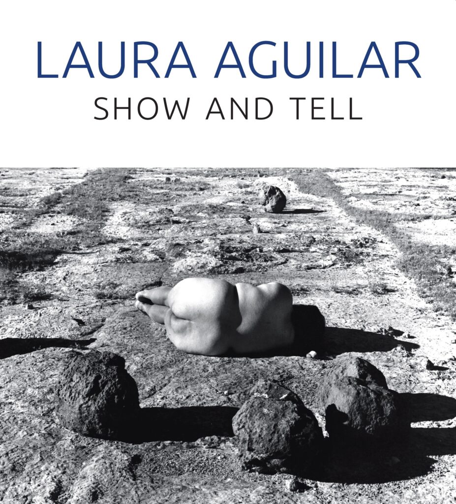 White book cover with a black and white photograph of the artist lying nude on a rocky landscape, and title in dark blue text.