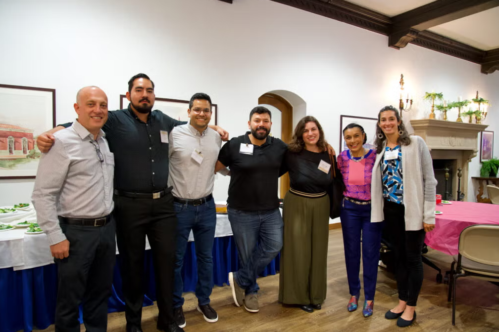Seven UCLA HSI faculty and staff members posing together at an indoor event.